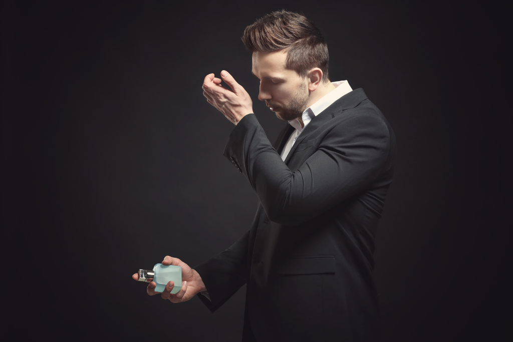 Elegancki mężczyzna wąchający nadgarstek tuż po aplikacji na nim perfum